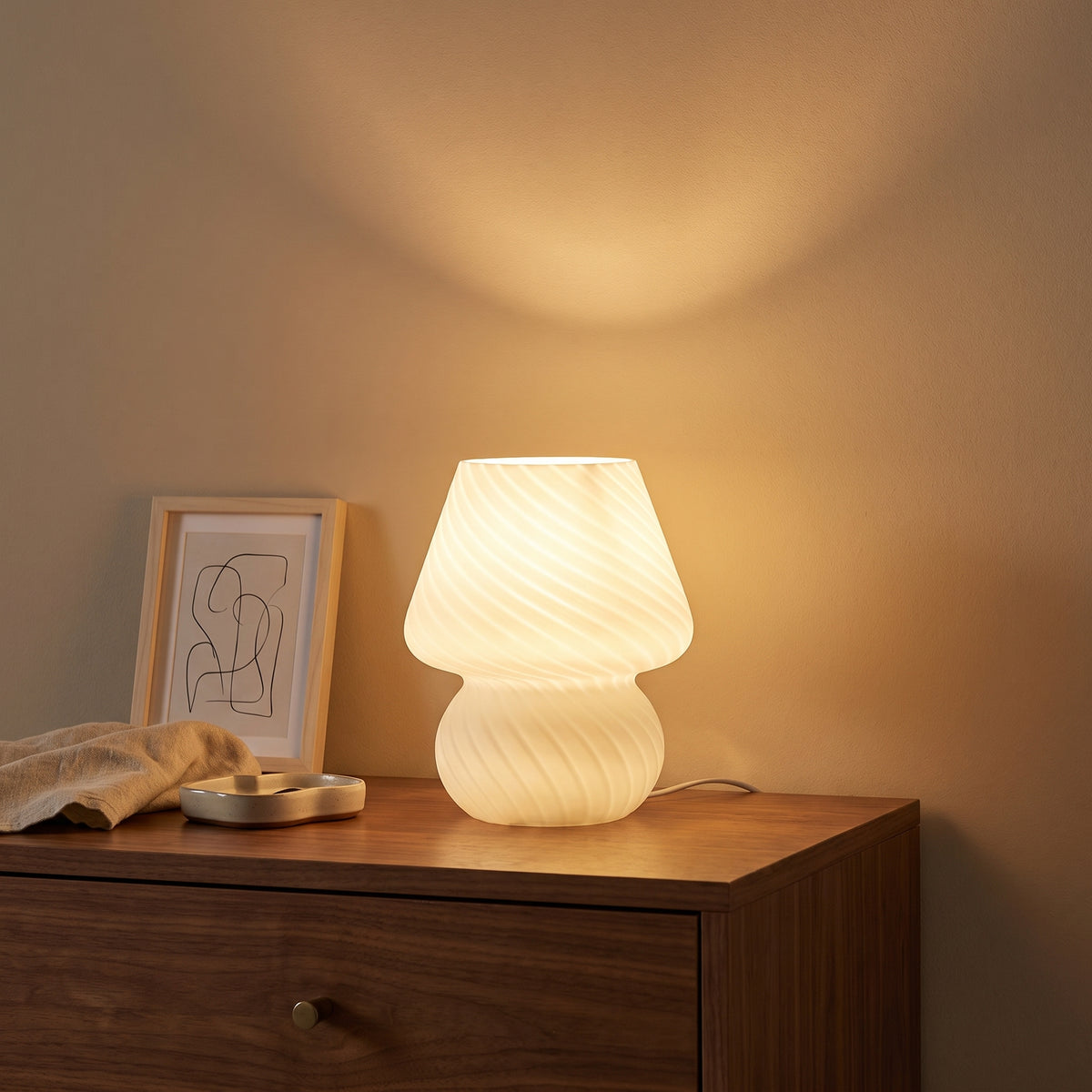 Mushroom lamp glowing on a walnut dresser at night, casting warm light on the wall