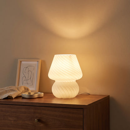 Mushroom lamp glowing on a walnut dresser at night, casting warm light on the wall