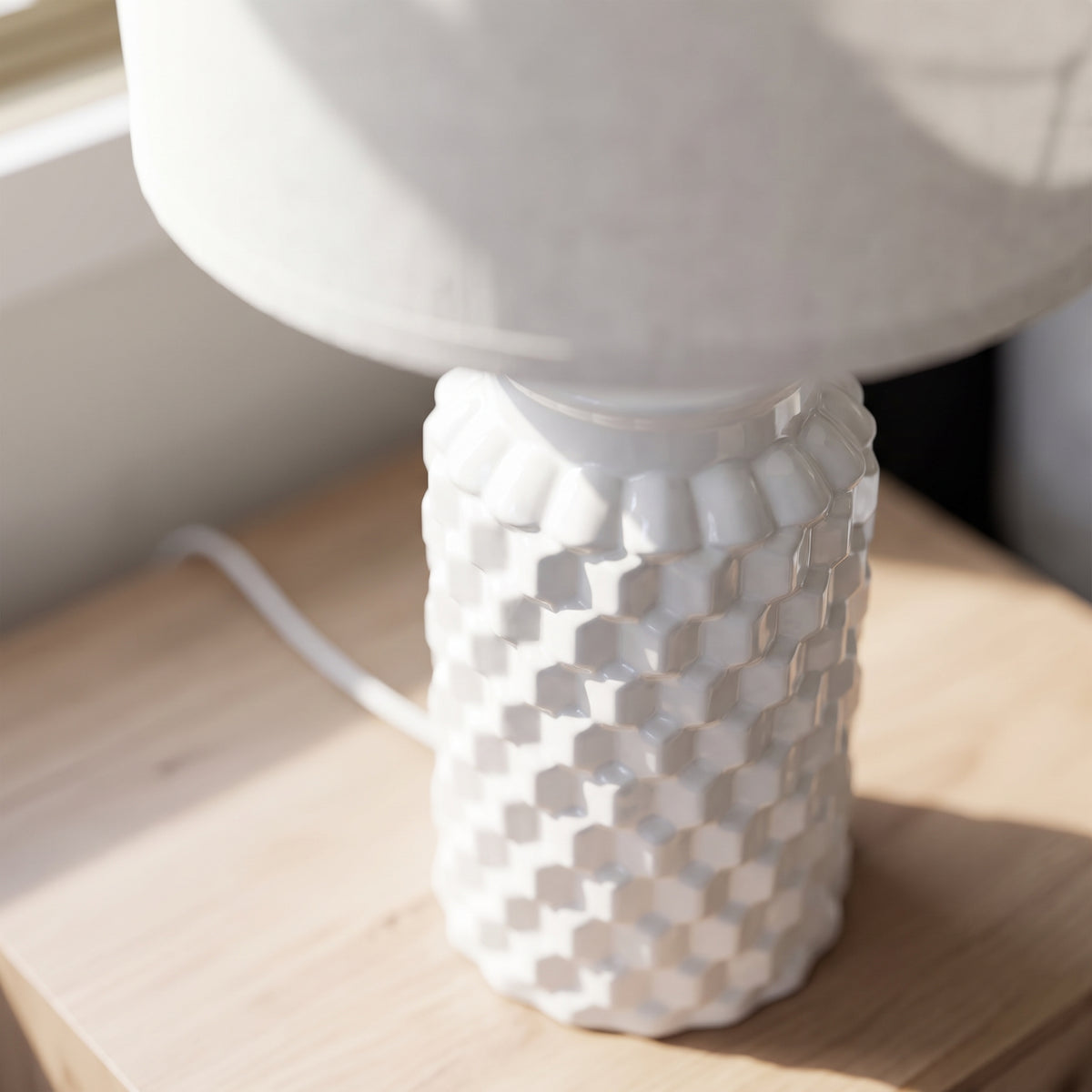 Close-up of the woven relief texture of the white ceramic lamp base