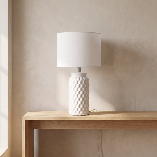 White textured ceramic table lamp with linen shade on an oak console