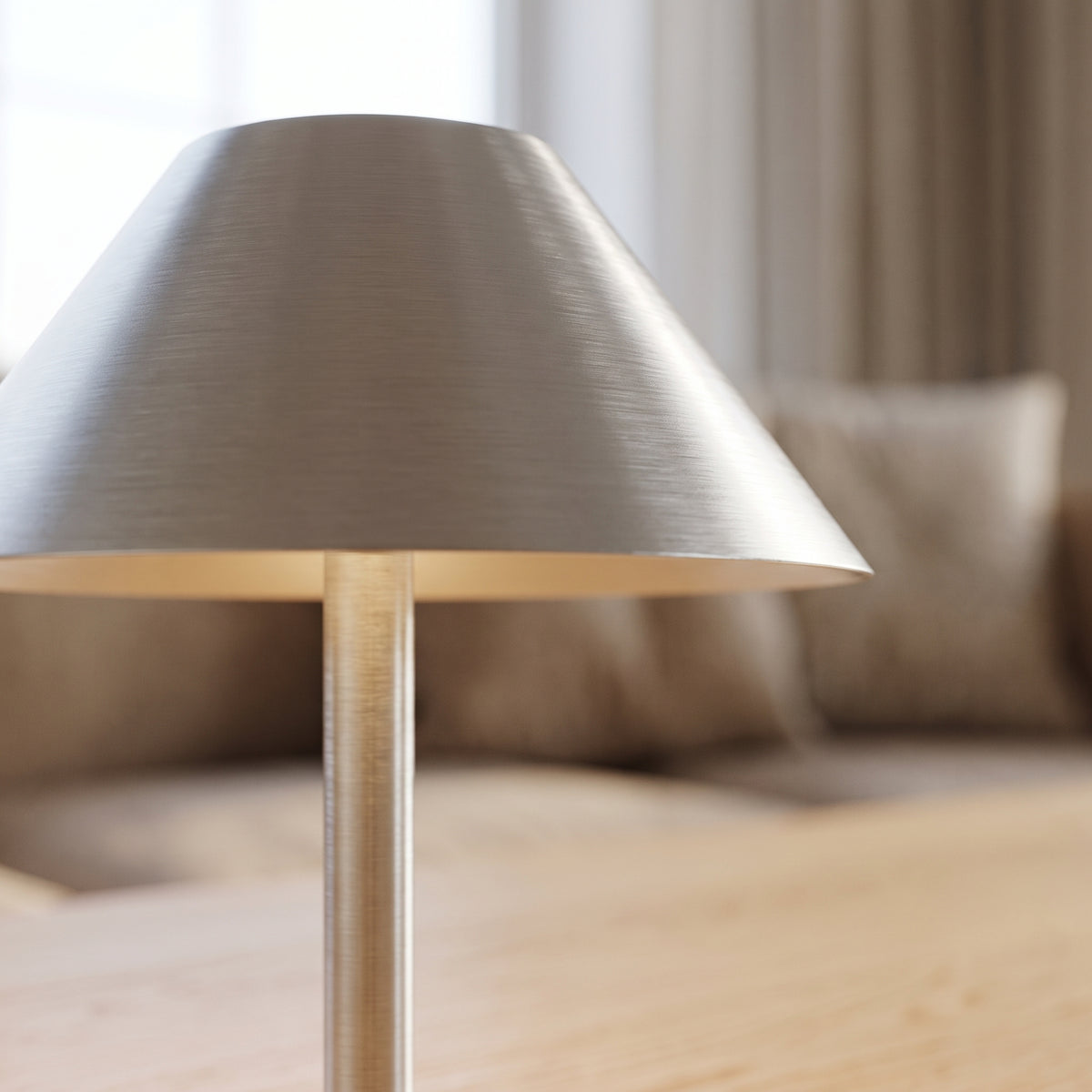 Close-up of the brushed metal shade and slim stem of the bedside lamp