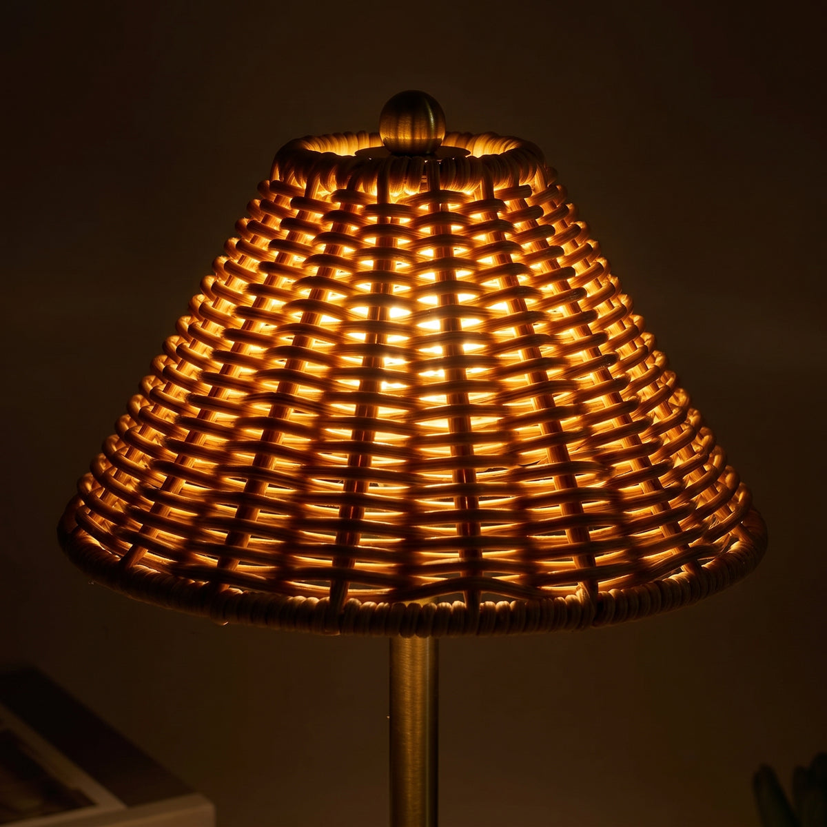 Rattan shade glowing from within at night, light threading through the weave