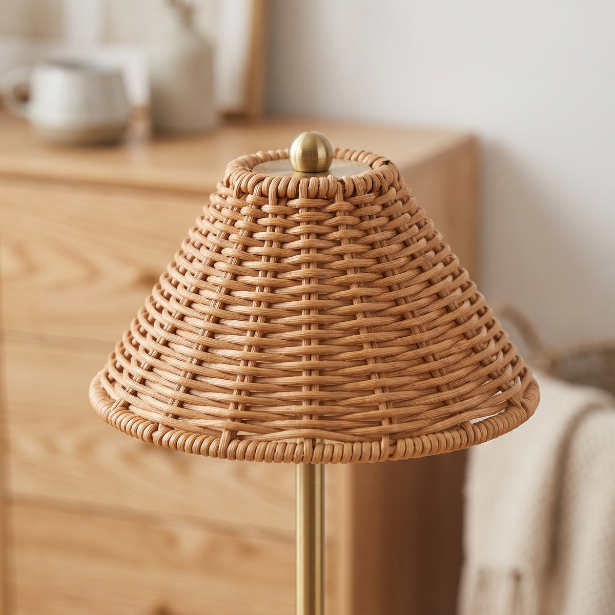 Close-up of the woven rattan shade and brass stem in daylight