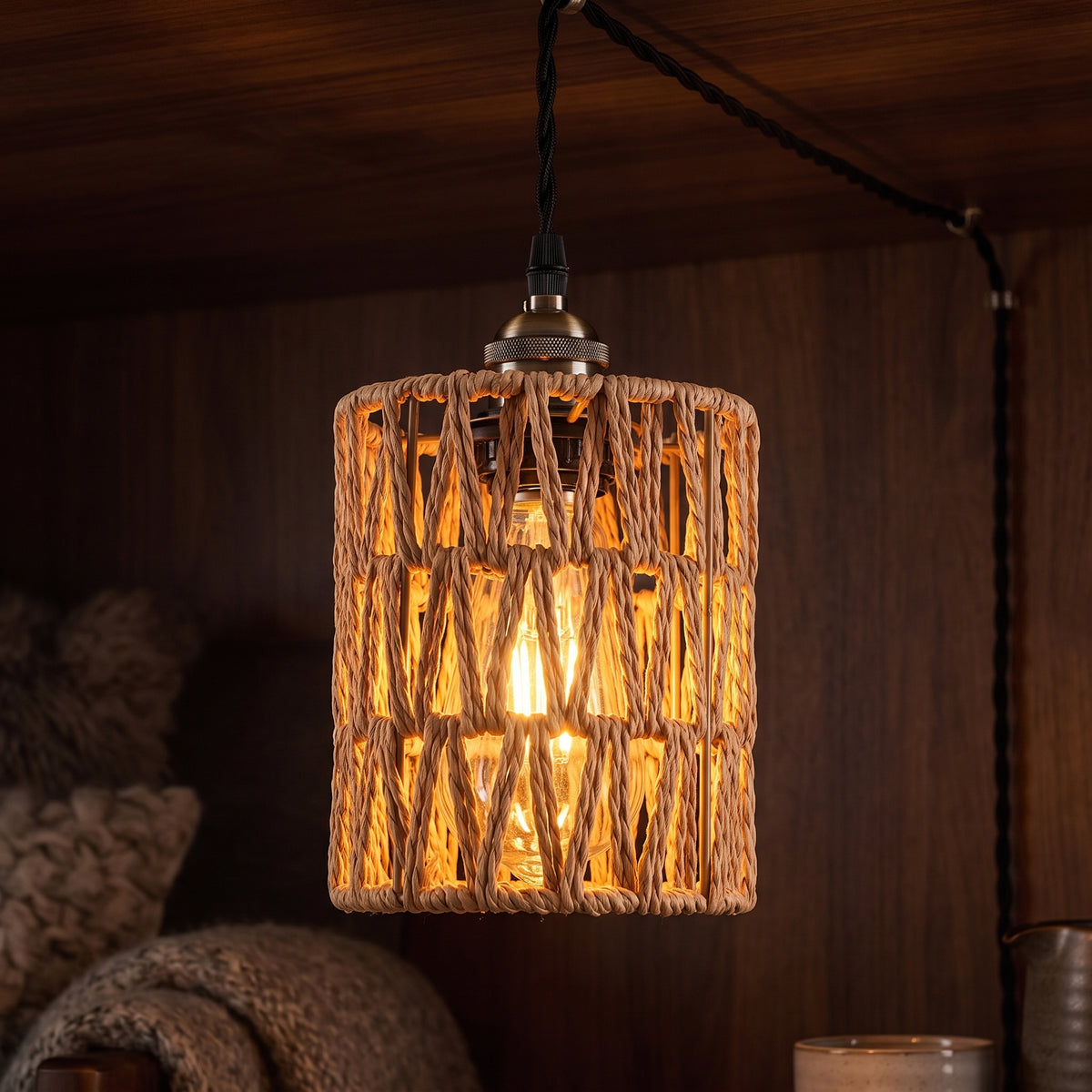 Warm Edison filament glowing inside the woven rattan shade at night